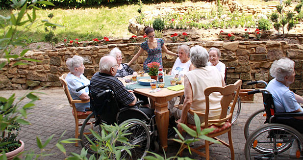 Bewohnerinnen und Bewohner in geselliger Runde im Garten