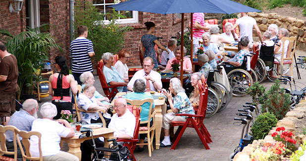 Bewohnerinnen und Bewohner bei einem Fest im Garten